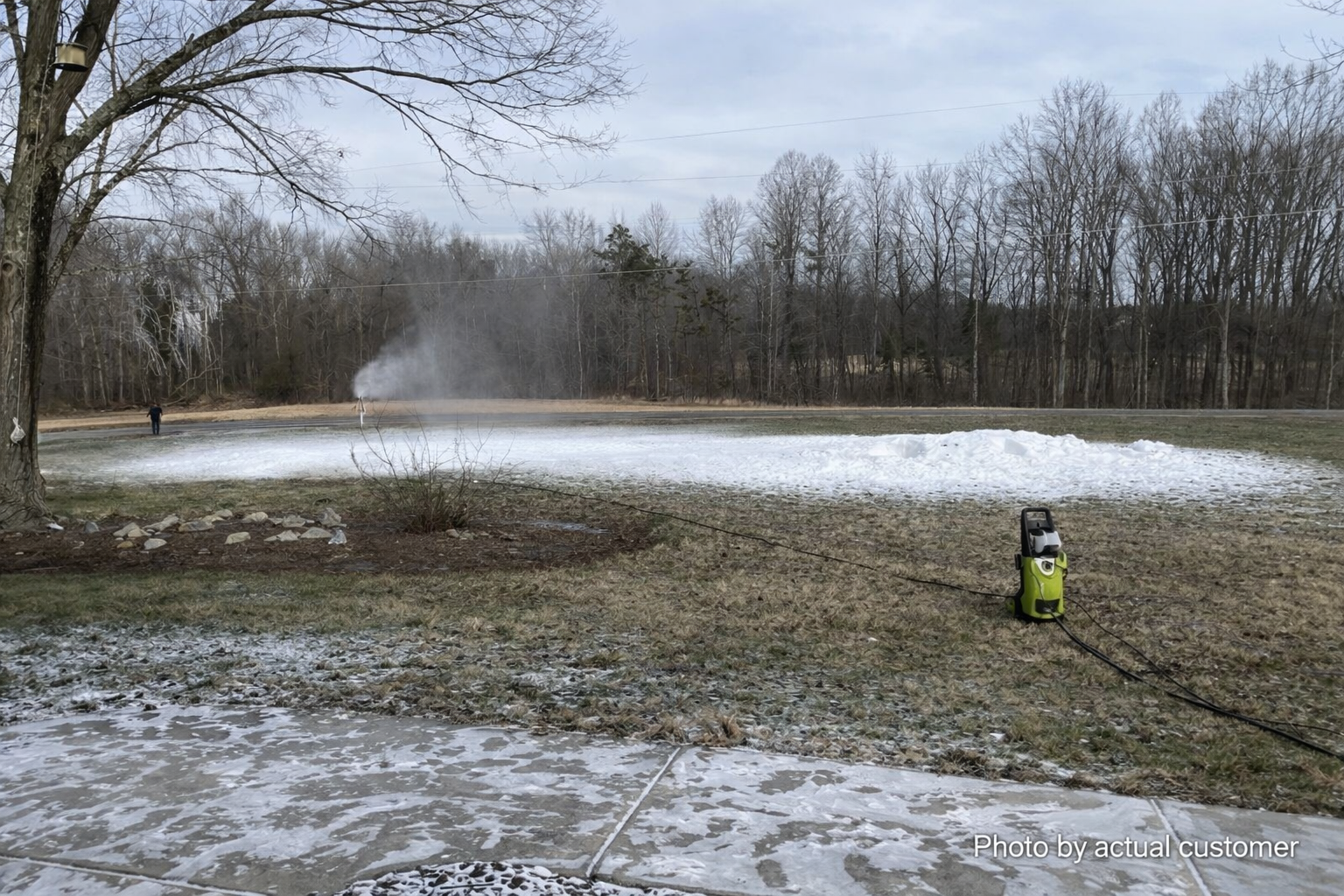 Wide view of snowmaker running across a large backyard field