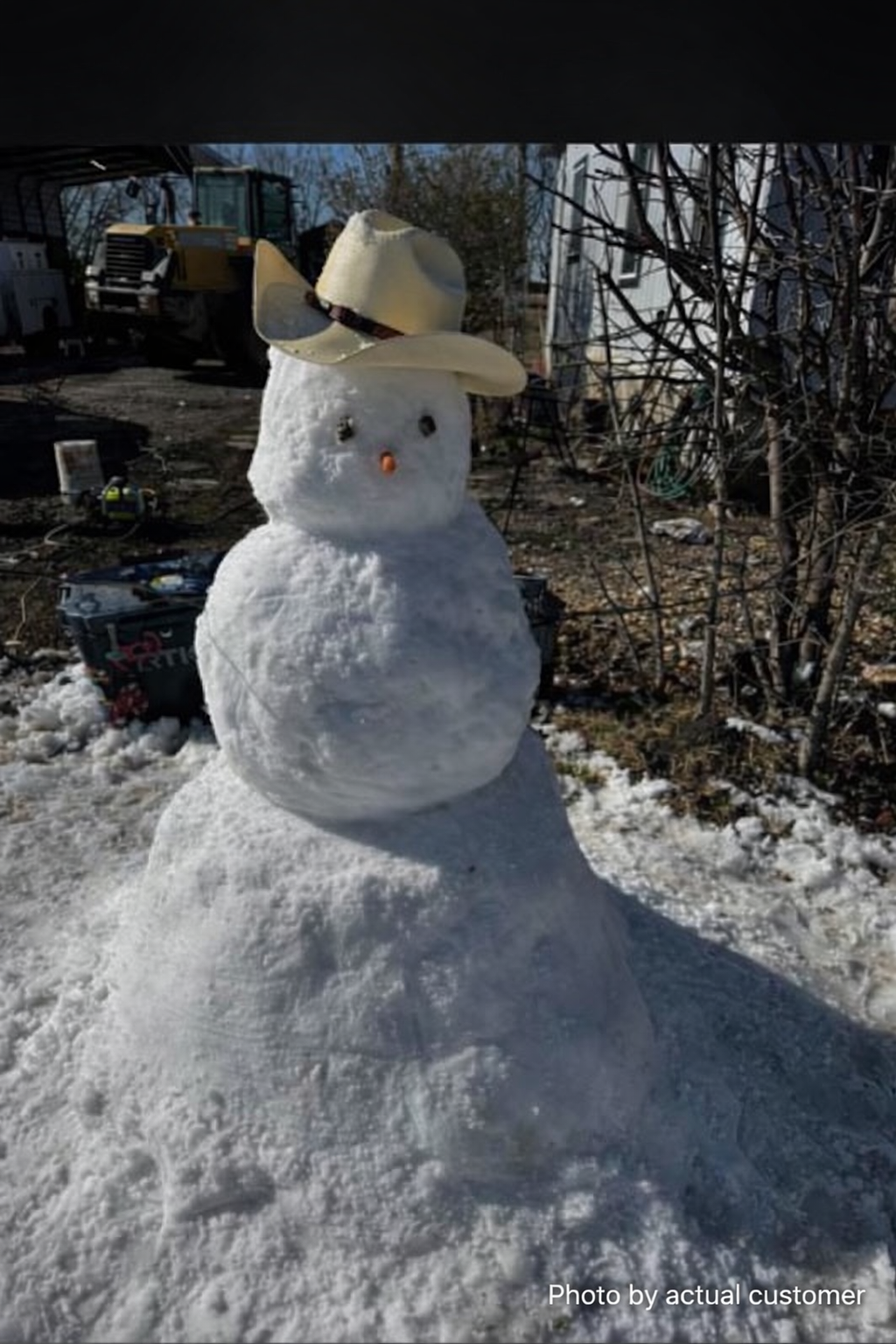 Snowman wearing a cowboy hat built from machine-made snow